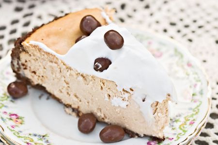 Cheesecake garnished with chocolate covered coffee bean with shallow DOF.の写真素材