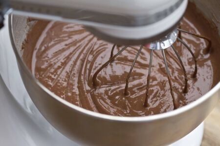Chocolate cake batter being mixed in an electric mixer.の写真素材
