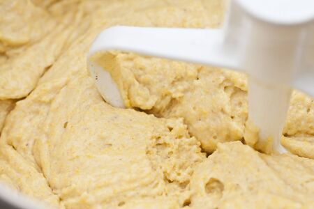 Abstract of cornbread dough being kneaded by machine. 