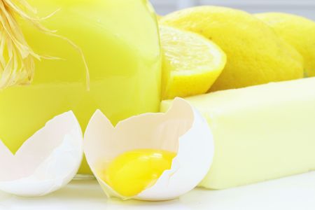 Ingredients for lemon curd with a glass jar of lemon curd ready to serve.の写真素材