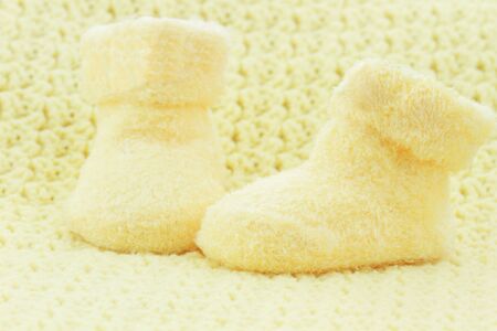 Yellow baby booties and blanket with room for text.の写真素材