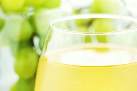 White grape juice in wine glasses with grapes in background. Water drops at 100%.の写真素材