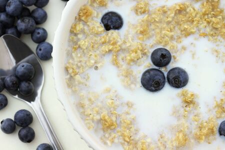 Hot oatmeal with cream and fresh blueberries. Shallow DOF.の写真素材