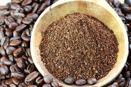 Coffee beans and ground coffee in a wooden spoon. 
の写真素材