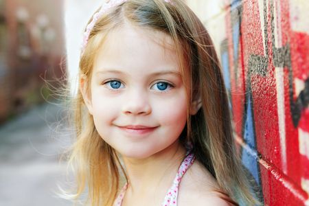Little girl in an urban setting smiles at the camera.の写真素材