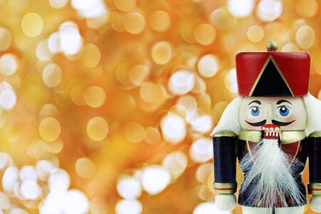 Wooden Nutcracker against a background of golden holiday lights .の写真素材