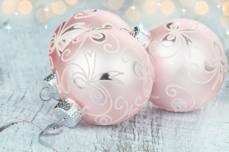 Pink Christmas ornaments lying on a rustic table. Shallow depth of field.の写真素材