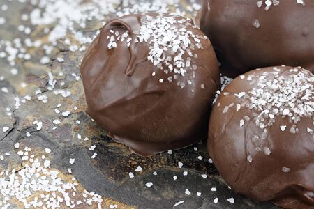 Chocolate truffle candies with sea salt. Shallow depth of field with selective focus on first...