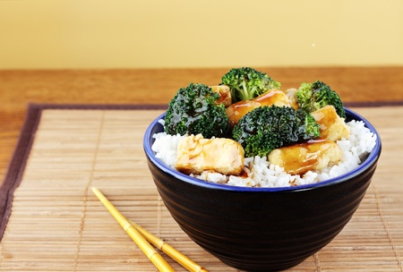 Vegetarian dish of stir fried tofu, broccoli and orange sauce with chopsticks. Selective focus on food with some blur on lower portion of image.

の写真素材