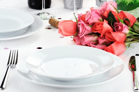 Romantic table setting for two with a bouquet of roses.の写真素材