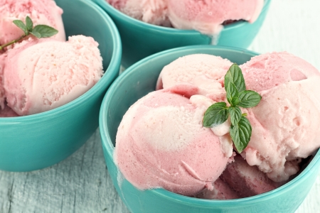 Three bowls of strawberry or raspberry sorbet, garnished with fresh mint.
の写真素材