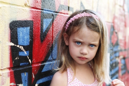 Worried little girl in an urban setting looking into the camera 