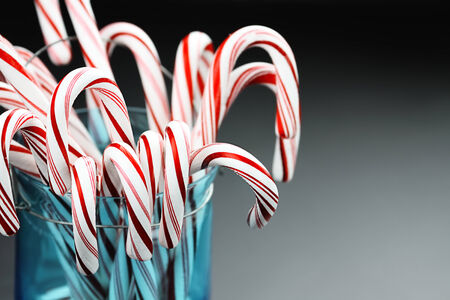 Jar of candy canes against a grey background with copy space.の写真素材