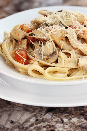 Chicken linguine with grilled chicken, tomatoes, mushrooms and freshly grated parmesan cheese.の写真素材