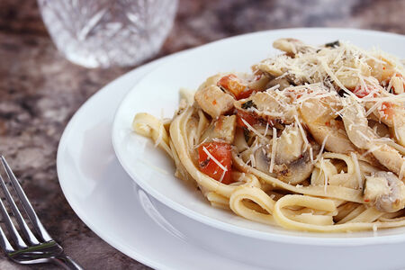 Chicken linguinie with grilled chicken, tomatoes, mushrooms and freshly grated parmesan cheese.の写真素材