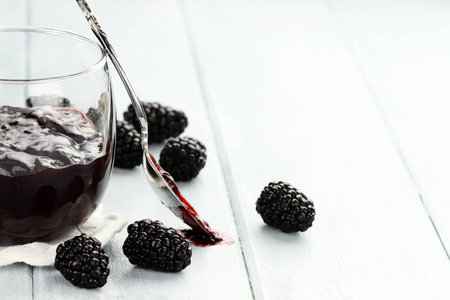 Delicious blackberry jelly and spoon with copy space  Extreme shallow depth of field 