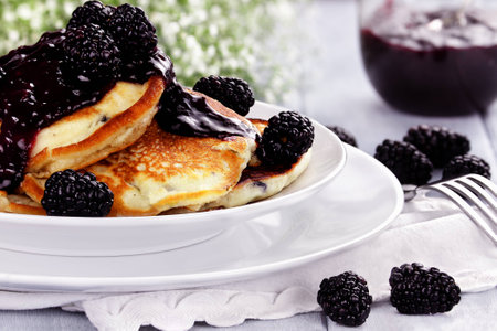 Delicious golden pancakes with fresh blackberries and blackberry jam  Extreme shallow depth of field の写真素材
