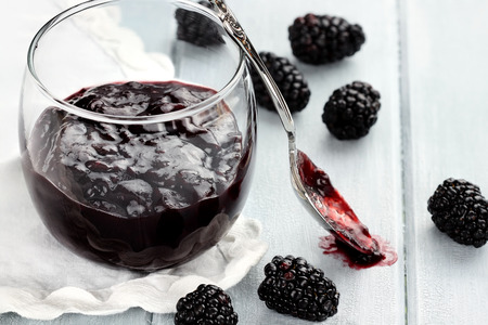 Messy spoon with blackberry jelly on a blue table  Extreme shallow depth of field and selective focus on jelly on spoon の写真素材