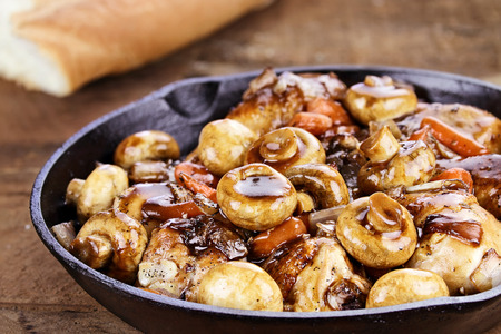 Coq Au Vin in rustic cast iron pan with shallow depth of field. Coq Au Vin in rustic cast iron pan with shallow depth of field.