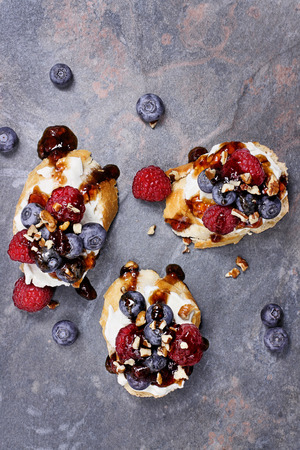Fruit Bruschetta with cheese spread, fresh berries, walnuts and a glaze of balsamic and fruit sauce.の写真素材