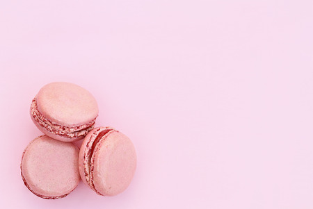 Three pink macarons over a pink background with copy space available.の写真素材