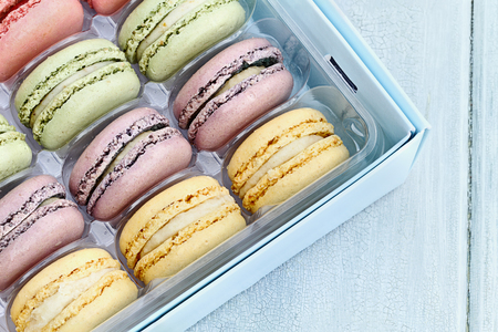 Box of fresh pastel colored macarons shot from overhead.の写真素材