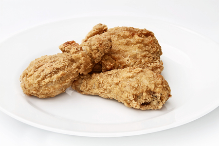 Three pieces of deep fried chicken on a plate against a white background.の写真素材