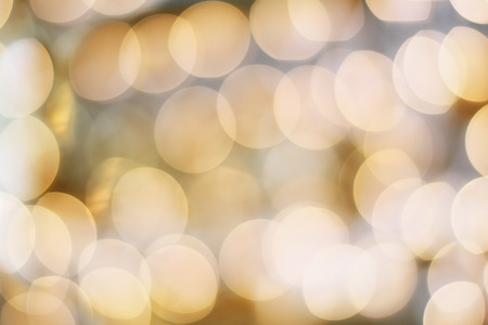 Abstract background of blurred golden holiday lights bokeh circles for Christmas background.