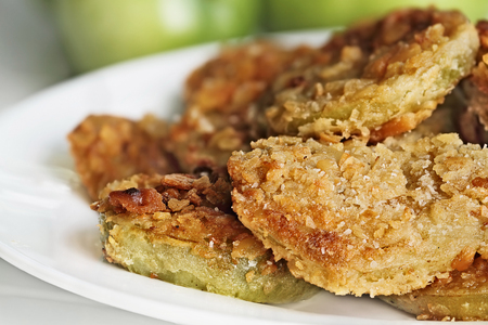 Plate of fresh fried green tomatoes. Tomatoes have been coated in cracker crumbs before frying. Extreme shallow depth of field with selective focus.の写真素材