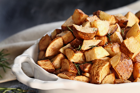 Roasted potatoes quartered and seasoned with rosemary and sea salt. Extreme shallow depth of field with selective focus on foreground.の写真素材