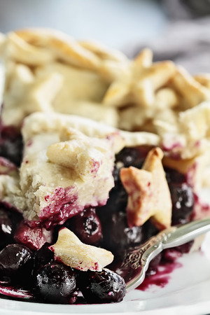 Abstract view of a slice of blueberry pie with lattice and stars crust. Extreme shallow depth of field with selective focus on bite of food on fork.の写真素材