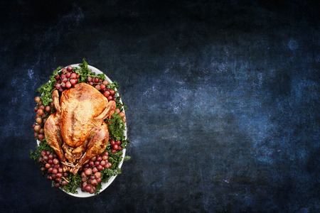 Roast Thanksgiving Day or Christmas turkey over a blank chalkboard or blackboard with room for copy space.の写真素材