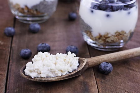 Kefir grains in wooden spoon in front of cups of Kefir Yogurt Parfaits. Kefir is one of the top health foods available providing powerful probiotics.  の写真素材
