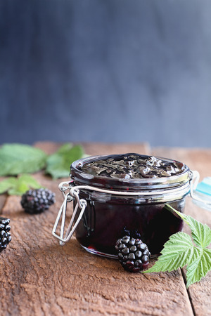 Homemade blackberry preserves in a canning glass bail jar with attached lid. Selective focus on jam.の写真素材
