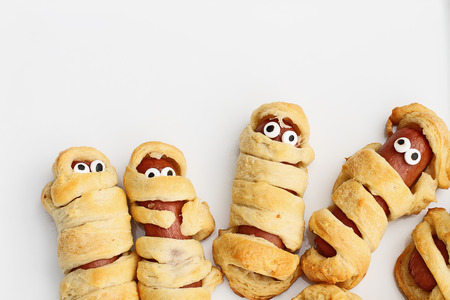 Fun food for kids. Halloween mummy hot dogs.  Weiners wrapped in croissant rolls to look like mummies on a plate. Altnerative to candy.の写真素材