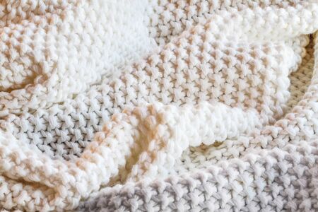 Abstract of a soft knit white and grey throw blanket with selective focus in center with blurred edges.の写真素材