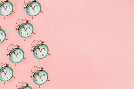 Daylight savings time concept. Set your clocks back with this flat lay retro beautiful alarm clocks set to 2 am over pink background. Pattern. Top view with copy space.の写真素材