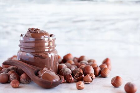 Fresh made homemade chocolate and hazelnut spread over a a white marble backdrop. Selective focus...