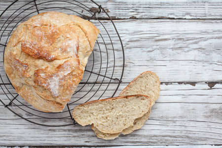 Top view of fresh homemade artisan bread cooling on a bakers rack. Flatlay.