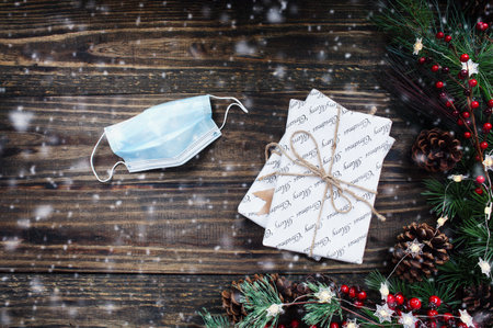 COVID celebration of Christmas and New Year's with medical mask and Christmas tree lights, pine...