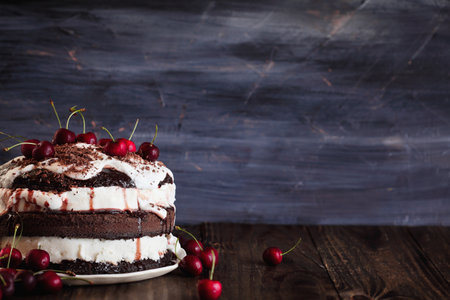 Delicious Black Forest Cherry Cake, Schwarzwald pie dessert, over a dark rustic wood table. Selective focus with blurred background and free space for text.の写真素材