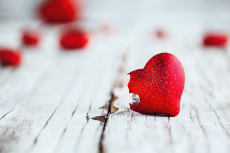 Valentines Day broken glass heart. Selective focus with extreme blurred foreground and background over a wooden table.の写真素材