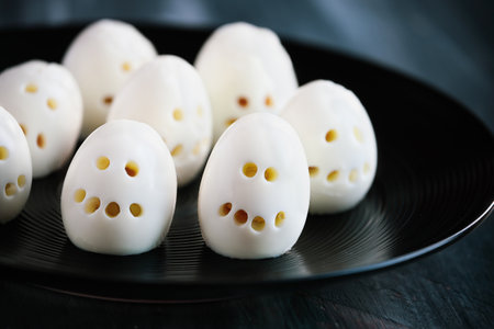 Fun food for kids. Hard boiled skeleton skull eggs perfect for Halloween parties. Alternative to candy. Shallow depth of field with selective focus. Blurred foreground and background.の写真素材