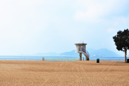 A life guard house at seaside, blue sky, calm sea, sandy beachの写真素材