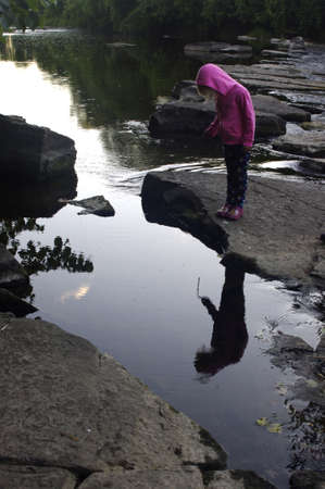 A young girl looking down into water
