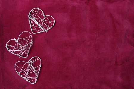 A red background with three wire heartsの写真素材