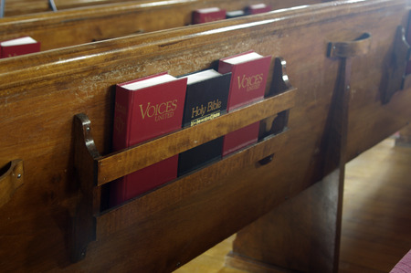 A Bible and song books in a church pewの写真素材