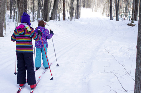 Girls Cross Country Skiing in woodsの写真素材
