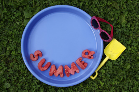 word summer in watermelon letters in blue trayの写真素材