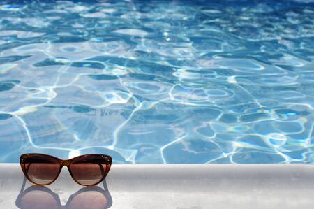 brown sunglasses by pool